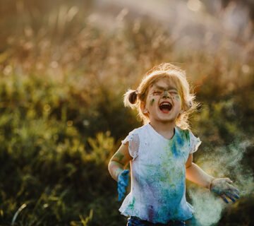 Charming little girl with white shirt covered with different paints 360x320